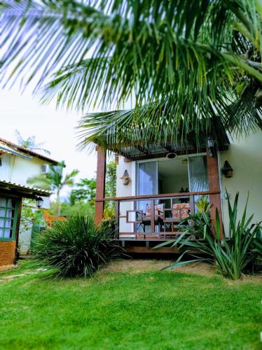 a house with a balcony and a palm tree at Solar Lisboa 100 m da Praia com vista para mar in Balneário Camboriú