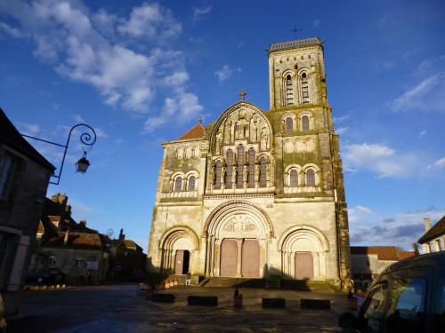 a large church with a tall tower with a blue sky at The Good Studio Vezelay in Vézelay