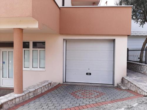 a white garage door on a house at Apartman Miletic in Mostar