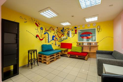 een wachtkamer met kleurrijke stoelen en een muur met graffiti bij Smart Hostel Sofia in Sofia