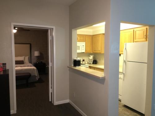 uma cozinha com um frigorífico e um quarto com uma cama em GetAways at Palm Springs Tennis Club em Palm Springs