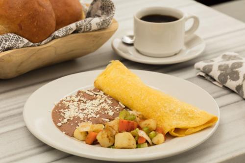 a plate of food with a sandwich and a cup of coffee at Medano Hotel and Spa in Cabo San Lucas