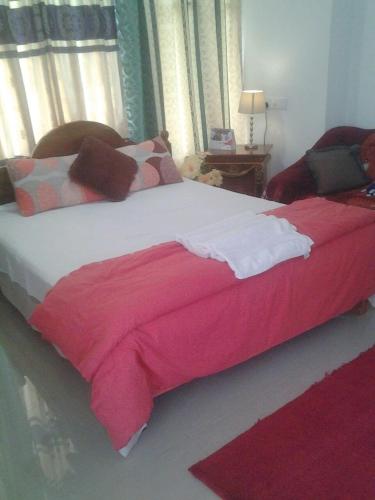 a bedroom with a large bed with a red blanket at Hamadhi guest in Haldummulla