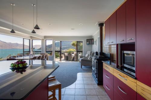 a kitchen with red cabinets and a view of the ocean at Matterhorn Lodge by Sotheby's Luxury Rental Homes in Queenstown