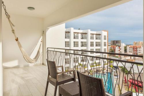 a balcony with chairs and a view of a building at Medano Hotel and Spa in Cabo San Lucas