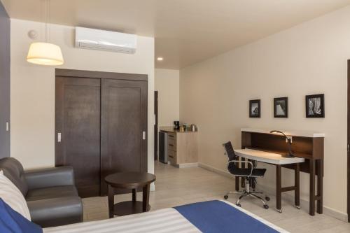 a bedroom with a bed and a desk and a desk at Medano Hotel and Spa in Cabo San Lucas