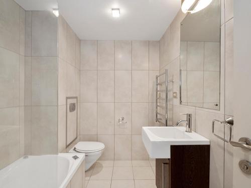 a white bathroom with a toilet and a sink at Roberts Retreat - Taupo Holiday Home in Taupo
