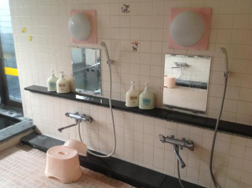 a bathroom with two mirrors and a toilet in a stall at Pension Ohno in Sobetsu