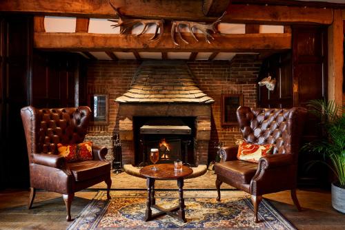 a living room with two chairs and a fireplace at Hotel Indigo - Stratford Upon Avon by IHG in Stratford-upon-Avon