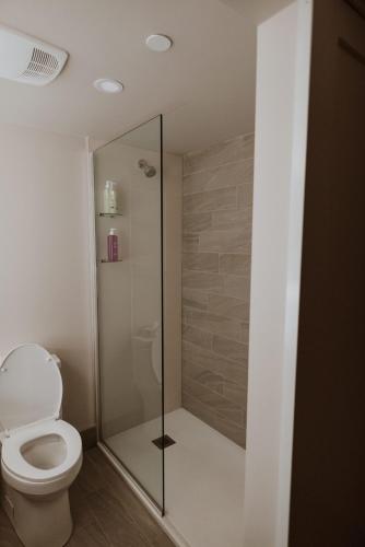 a bathroom with a toilet and a glass shower at Coast Nisku Inn & Conference Centre in Nisku