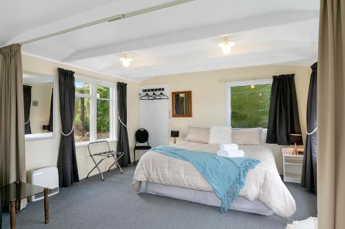 Un dormitorio con una cama grande y una ventana en Macbay Retreat - Macandrew Bay Holiday Home en Company Bay