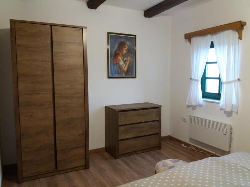 a bedroom with a closet and a dresser and a window at Kuća za odmor Cesarica in Marija Bistrica