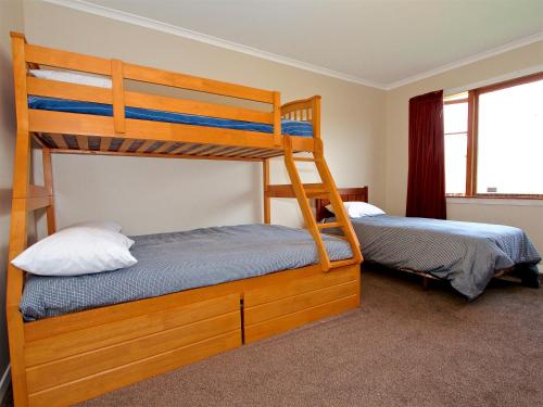 a bedroom with two bunk beds and a window at Raetihi Cottage- Raetihi Holiday Home in Raetihi