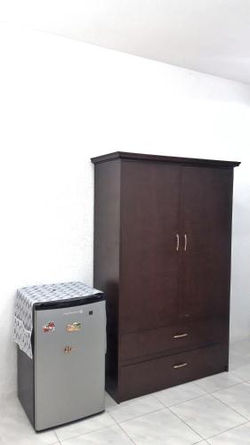 a dark wood cabinet next to a small locker at Jah’s Anemone Dive Guesthouse in Moalboal