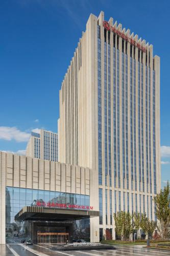 a large building with a sign on the front of it at Wanda Realm Harbin Hotel in Harbin