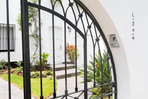 a view through a wrought iron gate into a garden at Lima 18 Boutique in Lima