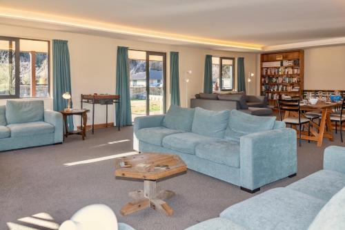 a living room with two blue couches and a table at GraceWorks - Hanmer Springs in Hanmer Springs