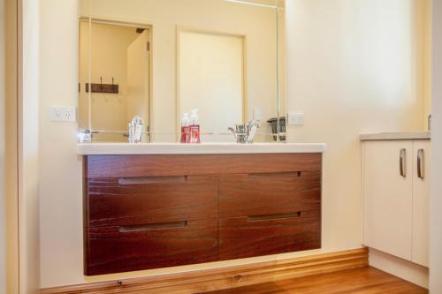 a bathroom with a wooden dresser with a mirror at GraceWorks - Hanmer Springs in Hanmer Springs