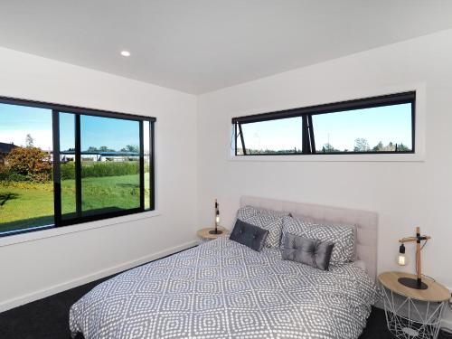 una camera con un letto e due finestre di Pinot Longbox - Martinborough Holiday Home a Martinborough