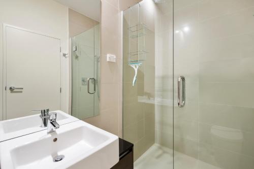 a bathroom with a sink and a glass shower at Riverside Villa - Taupo Holiday Home in Taupo