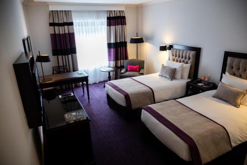a hotel room with two beds and a desk at Sofitel Buenos Aires Recoleta in Buenos Aires