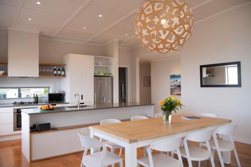 a kitchen and dining room with a wooden table and chairs at Waimarama Heights - Waimarama Holiday Home in Waimarama