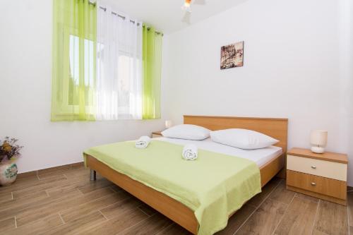 una camera da letto con un letto e due asciugamani di Apartments Ivica - garden terrace a Slatine