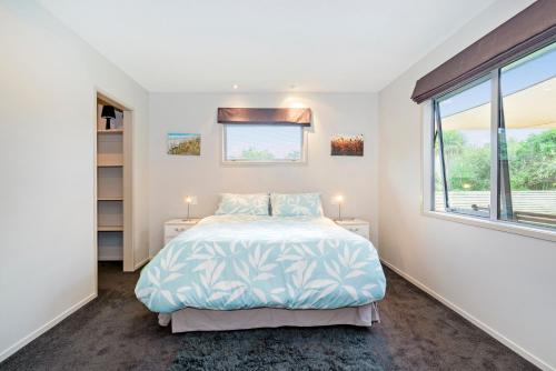 Un pat sau paturi într-o cameră la The Blue Rendevous - Whangamata Holiday Home