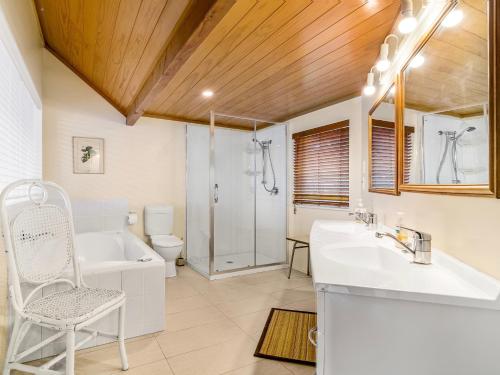 Rotoiti的住宿－Lakefront Sublime - Lake Rotoiti Holiday Home，带浴缸、水槽和淋浴的浴室