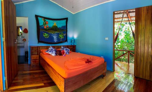 a bedroom with a bed in a blue room at Las Caletas Lodge in Drake
