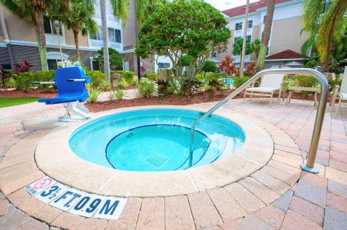 una pequeña piscina con una fuente de agua en un patio en Best Western Plus Orlando Lake Buena Vista South Inn & Suites en Kissimmee