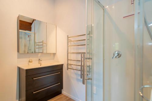 La salle de bains est pourvue d'un lavabo et d'une douche. dans l'établissement Bluebird Bach - Onemana Holiday Home, à Opoutere