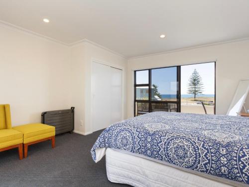 a bedroom with a bed and a view of the ocean at Sand Castles - Mount Maunganui Holiday Home in Mount Maunganui