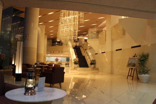 a lobby with a chandelier and a table in a building at The Gran Resort Princess Arima in Kobe