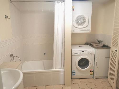 a bathroom with a sink, toilet and bathtub at The Oasis Apartments in Brisbane