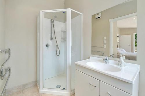 a white bathroom with a shower and a sink at Lavender Country Cottage - Arrowtown Holiday Home in Arrowtown