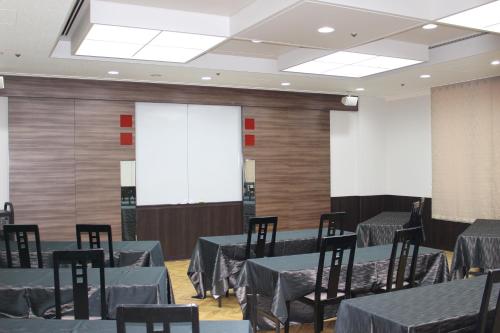 a banquet hall with tables and chairs and a projection screen at The Gran Resort Princess Arima in Kobe