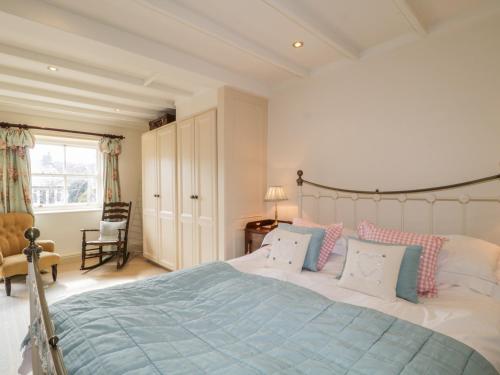 プーリー・ブリッジにあるBlacksmiths Cottageのベッドルーム1室(ベッド1台、椅子、窓付)