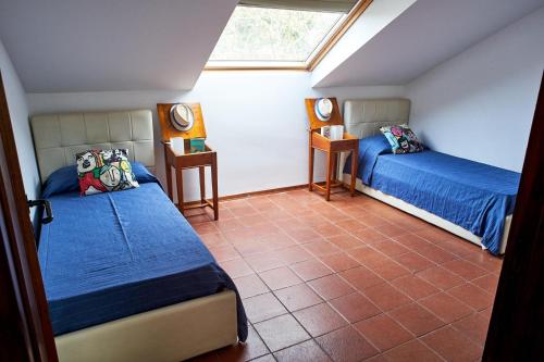 1 dormitorio en el ático con 2 camas y ventana en LuminHouse Mondello Valdesi, en Palermo