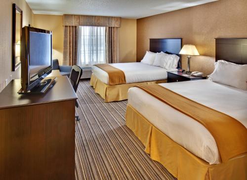 a hotel room with two beds and a flat screen tv at Holiday Inn Express Hotel & Suites Council Bluffs - Convention Center Area by IHG in Council Bluffs