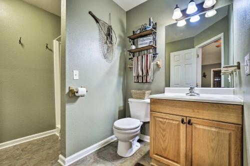 y baño con aseo, lavabo y espejo. en Guntersville Lake Home with Deck and Covered Boat Slip, en Scottsboro