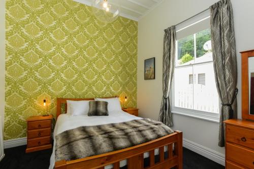 1 dormitorio con cama y ventana en Juliet's Cottage - Napier Holiday Home en Napier