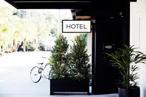 
a bicycle parked in front of a building with a sign at The Bower Byron Bay in Byron Bay
