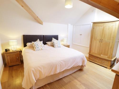 a bedroom with a large white bed with two pillows at 3 Bythynnod yr Aran in Bala