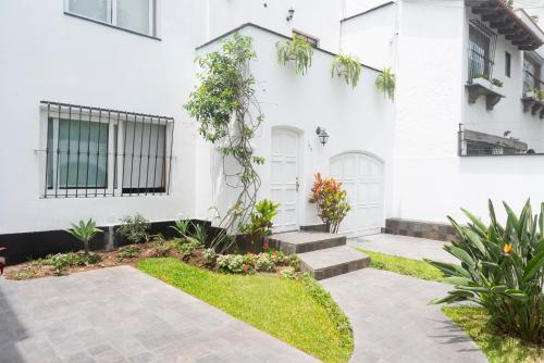 a white house with a garden in front of it at Lima 18 Boutique in Lima
