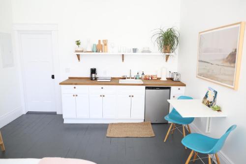 a kitchen with a sink and blue chairs at The Burlington in Los Angeles
