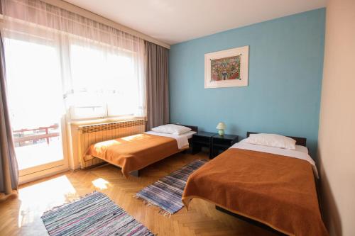 a bedroom with two beds and a large window at Apartment Kralj in Selce