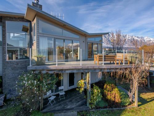 a house with a deck with a bench on it at Lake Views on Yewlett - Queenstown Holiday Home in Queenstown