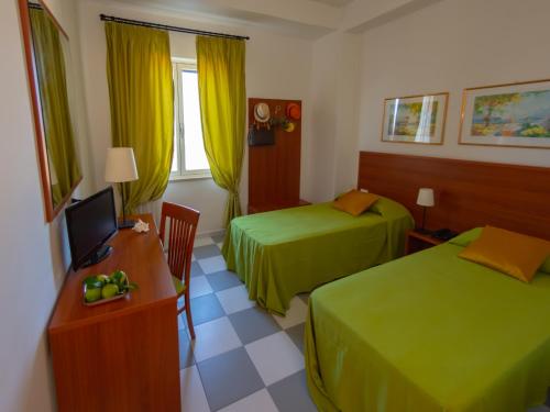 a hotel room with two beds and a desk with a computer at Hotel Solaria in Rodi Garganico