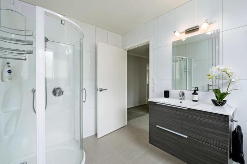 a white bathroom with a sink and a shower at Maison de Maude - Lake Hawea Holiday Home in Lake Hawea